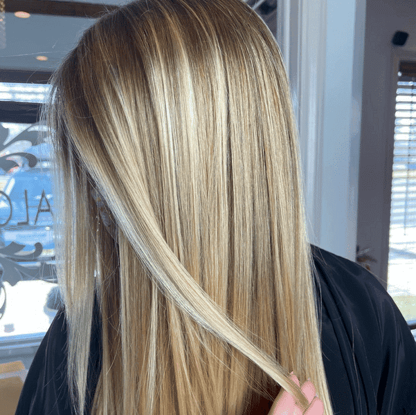 Long blond hair with soft highlights at a salon.